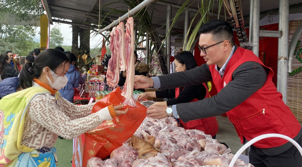 Ông Nguyễn Tuấn Anh, Phó Chủ tịch Hội Chữ thập đỏ tỉnh hỗ trợ người dân đổi sản phẩm thiết yếu tại Chương trình 