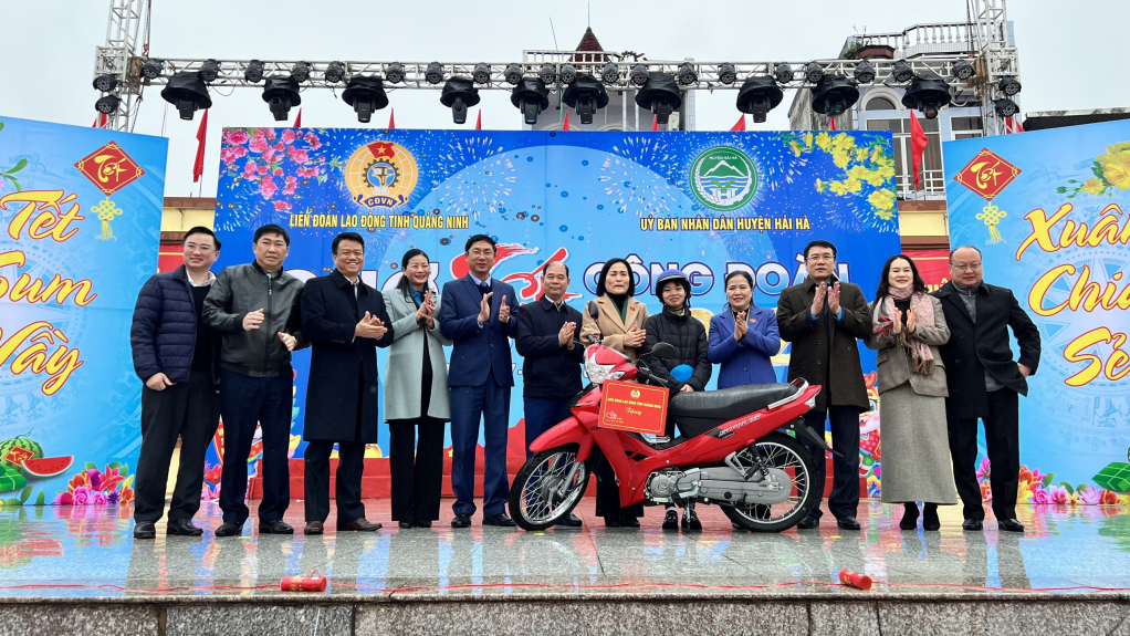Các đồng chí lãnh đạo Quốc hội, LĐLĐ tỉnh, huyện Hải Hà trao tặng quà xe máy - phần thưởng có giá trị lớn nhất trong trò chơi bốc thăm trúng thưởng cho CNLĐ.