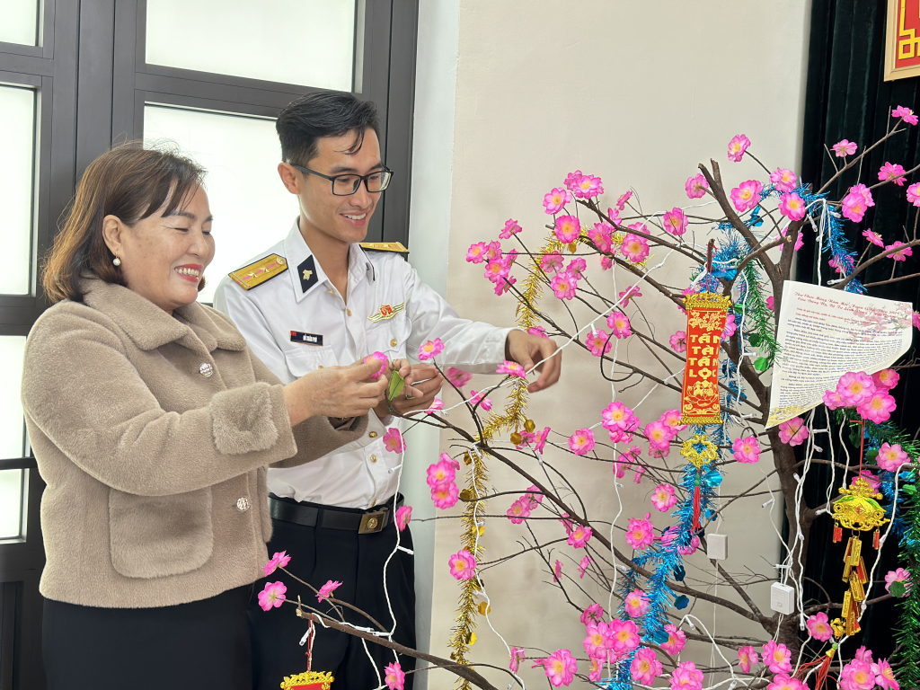 Chiến sỹ và cô giáo trường tiểu học Lý Sơn trang trí cây đào đón Tết.