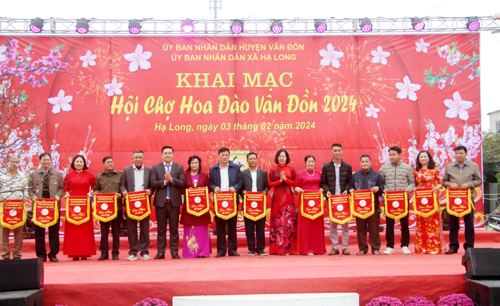 Ban Tổ chức Hội chợ hoa đào Vân Đồn tặng Cờ lưu niệm cho các đơn vị tham gia hội chợ.