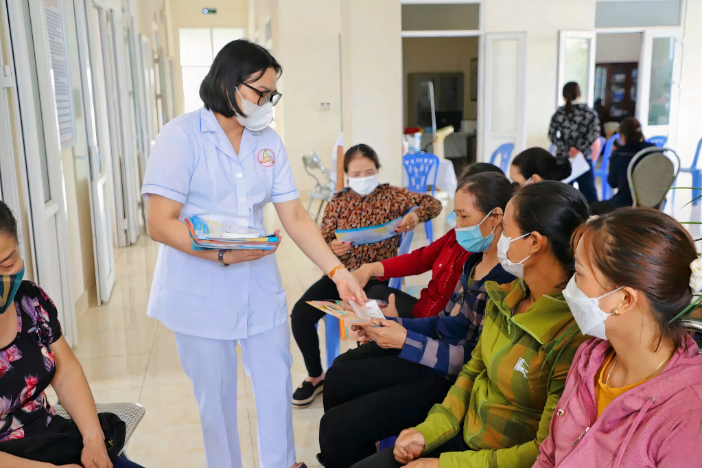 Cán bộ Trung tâm Y tế TX Đông Triều phát tờ rơi tuyên truyền nâng cao nhận thức về ung thư vú cho phụ nữ.