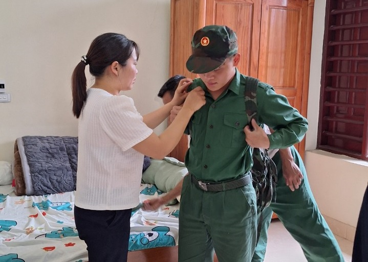 Tân binh Nguyễn Mạnh Hùng đang mặc thử quân phục mới được cấp phát.