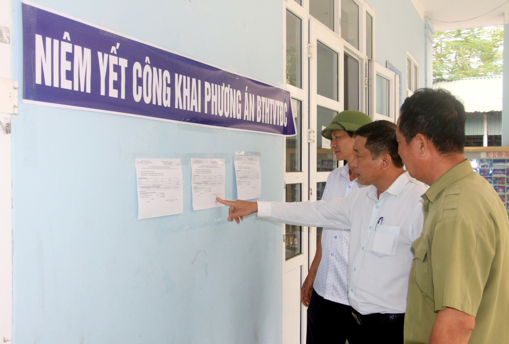 Cán bộ, nhân viên Quận 7B, huyện Quang Hanh (TP Cẩm Phả) đang theo dõi việc thực hiện phương án bồi thường, hỗ trợ tái định cư trên địa bàn.  Ảnh: Mạnh Trường