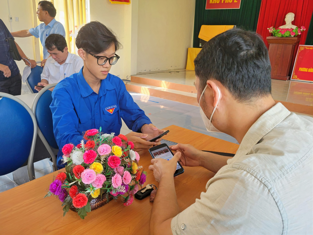 Chu Quốc Phong hướng dẫn người trên địa bàn thị trấn Cái Rồng cài đặt định danh điện tử VNeID.