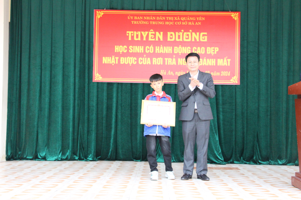 Ông Dương Văn Hào, Phó Chủ tịch UBND TX Quảng Yên tặng giấy khen cho em Nguyễn Văn Khôi, lớp 6E, trường THCS Hà An vì có hành động đẹp nhặt được của rơi trả người đánh mất.