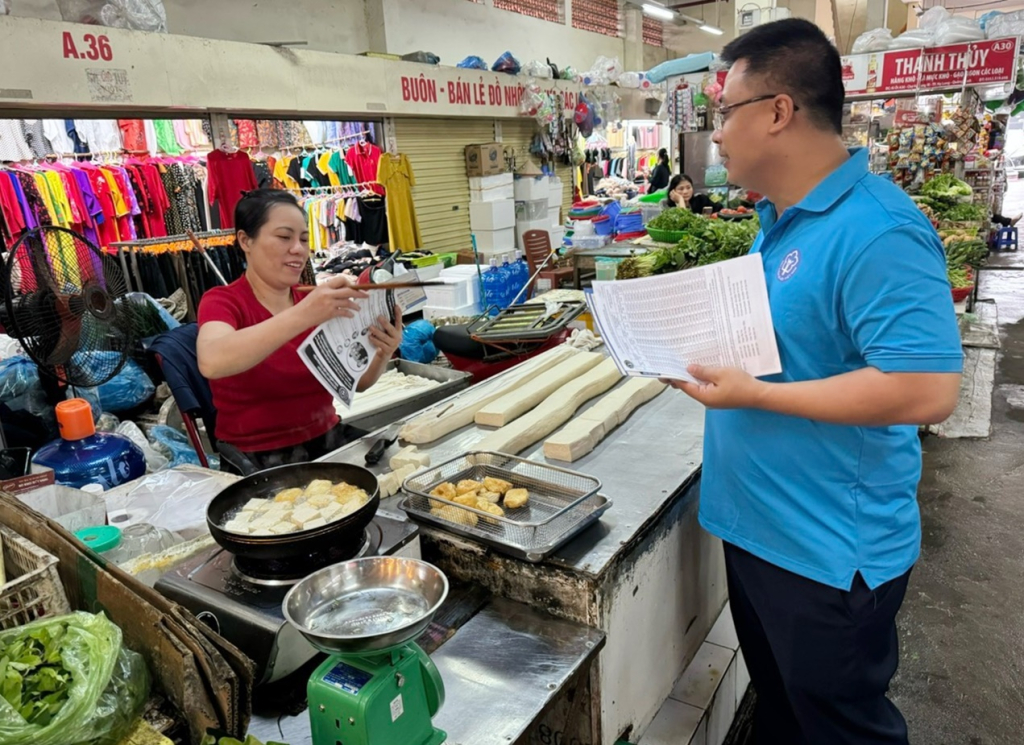 Cán bộ Đoàn Thanh niên Cơ quan BHXH tỉnh tuyên truyền tiểu thương kinh doanh tại Chợ Cột 5 (phường Hồng Hà, TP Hạ Long) tham gia BHXH tự nguyện.