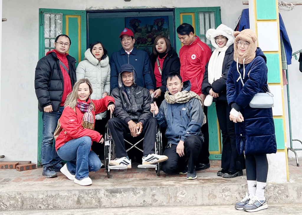 Anh Nguyễn Tiến Huân (người ngồi bên phải) cùng các thành viên CLB Ngân hàng máu sống 24h, tặng xe lăn và quà cho người khuyết tật tại xã Ngọc Vừng (huyện Vân Đồn) tháng 1/2024.