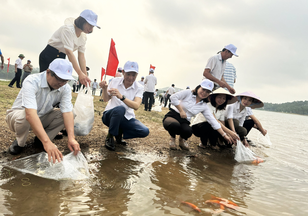 Cán bộ, nhân dân TP Uông Bí thả cá táo tạo nguồn lợi thuỷ sản tại khu vực hồ Yên Trung ngày 1/4.