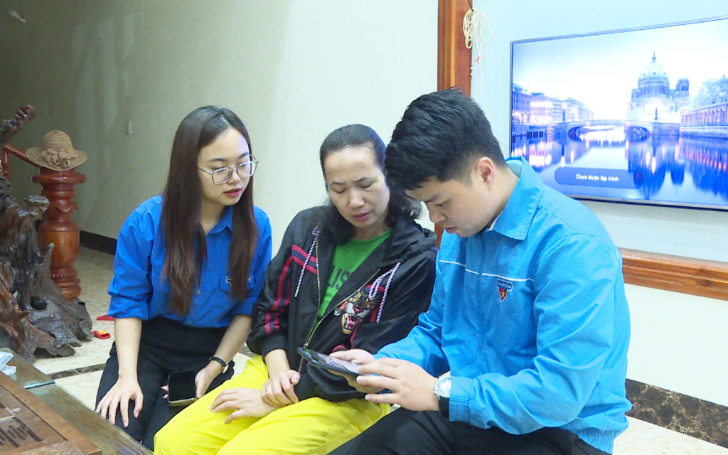 Đoàn viên, thanh niên thị trấn Đầm Hà hướng dẫn người dân sử dụng các tiện ích số trên điện thoại thông minh. Ảnh: Ngọc Trâm