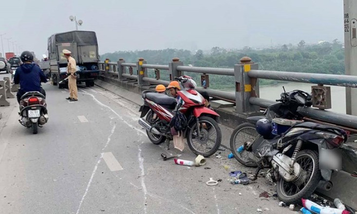 Ôtô tông bay dải phân cách, văng trúng 2 xe máy trên cầu Thanh Trì