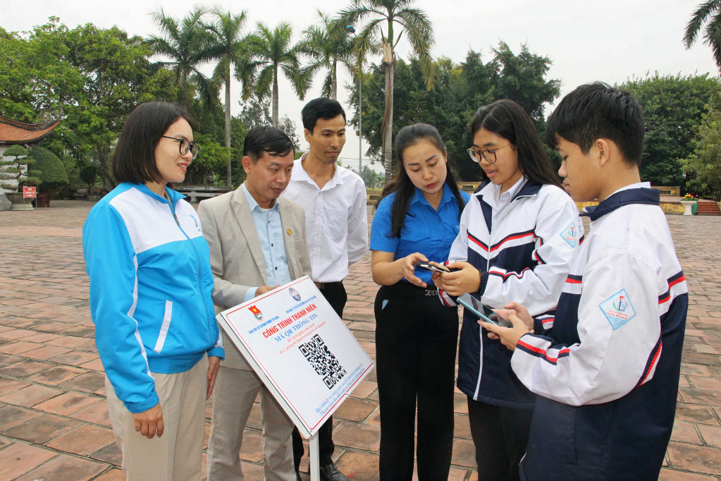 Chị Trần Thị Minh Tâm hướng dẫn người dân và ĐVTN quét mã QR-Code tìm hiểu về di tịch lịch sử Bạch Đằng.