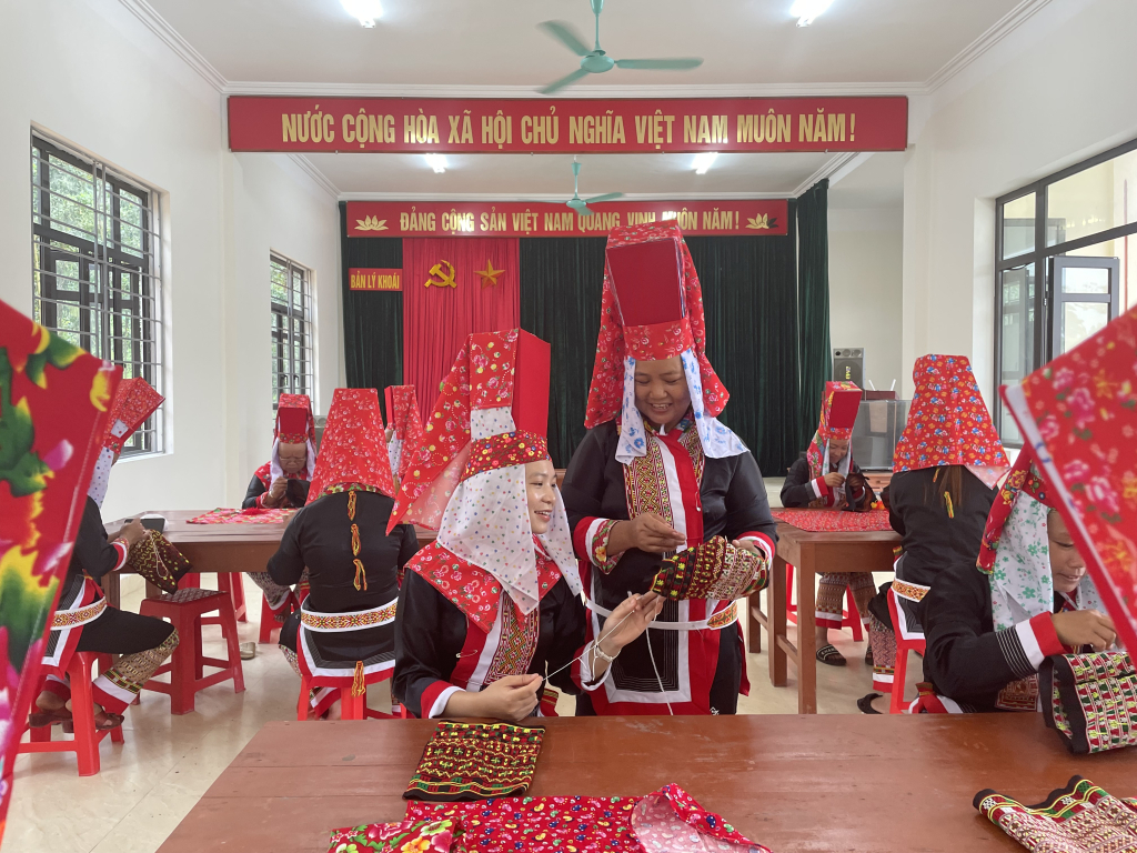 Phụ nữ xã Quảng Lâm (huyện Đầm Hà) dạy nhau học thêu trang phục truyền thống. Ảnh: Lan Anh.
