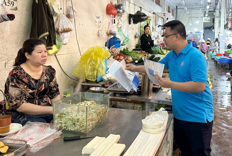 Cán bộ BHXH tỉnh tuyên truyền tiểu thương tại Chợ Cột 5 (phường Hồng Hà, TP Hạ Long) về chính sách BHXH tự nguyện tháng 3/2024.
