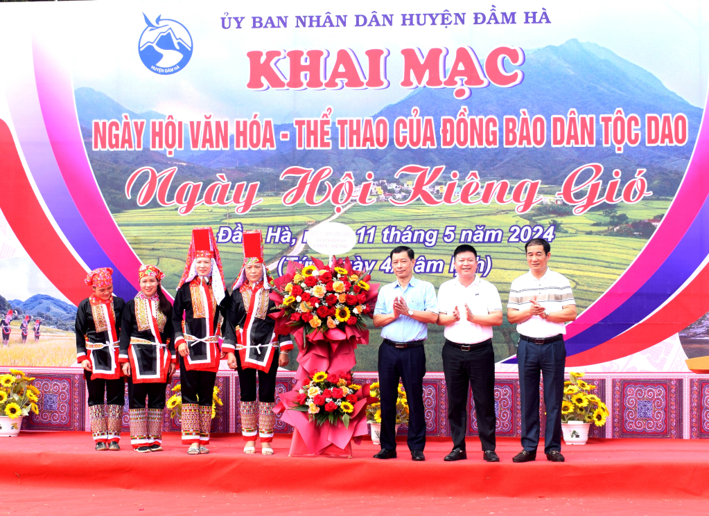 Các lãnh đạo huyện Đầm Hà tặng đại diện người Dao tại xã Quảng An lẵng hoa tươi thắm
