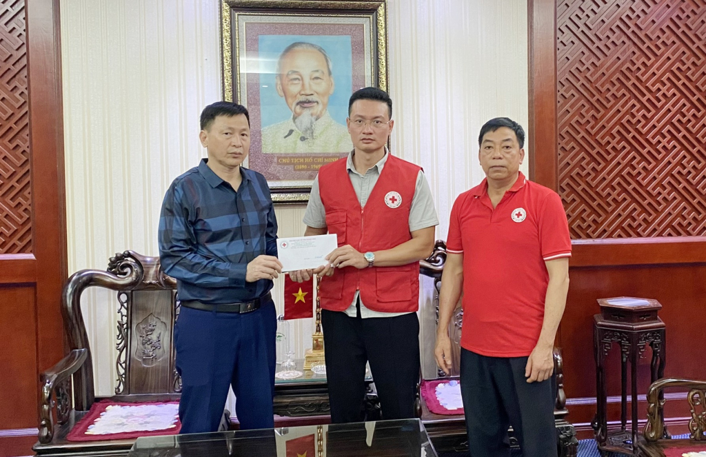 Ông Nguyễn Tuấn Anh, Phó Chủ tịch Hội Chữ thập đỏ tỉnh trao cho đại diện Công ty Than Quang Hanh hỗ trợ các nạn nhân bị tai nạn lao động.