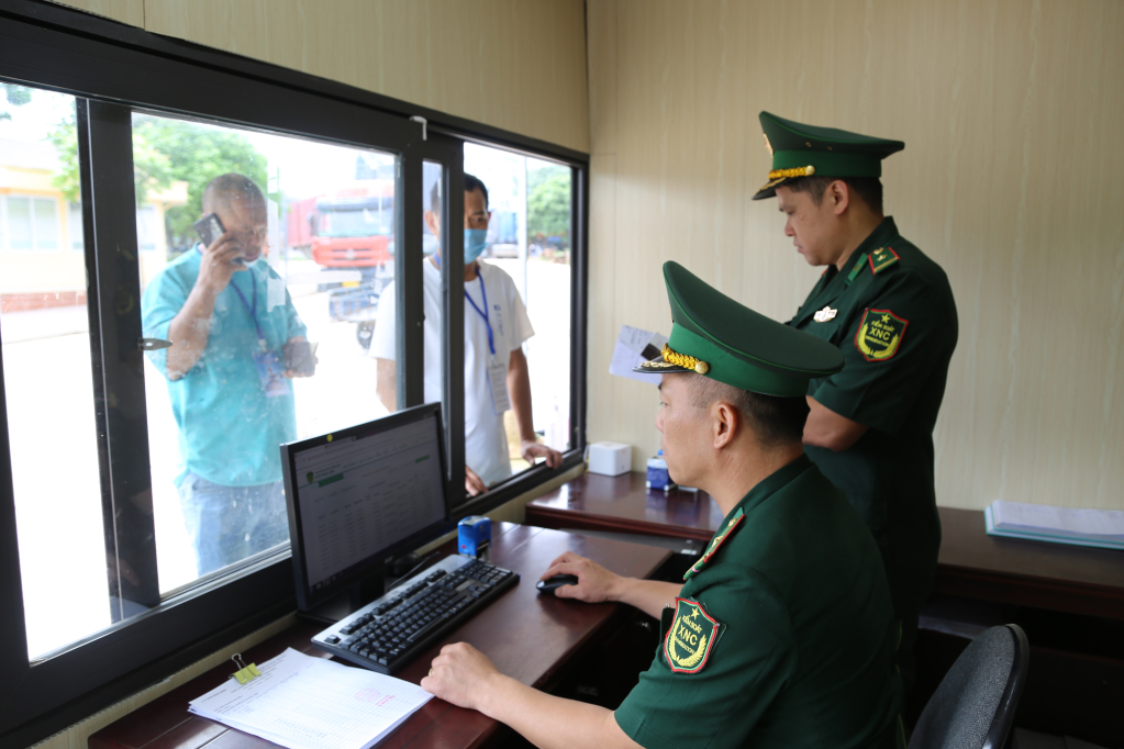 Thiếu tá Nguyễn Văn Vương cùng CBCS Trạm Biên phòng Cửa khẩu Hoành Mô làm thủ tục XNC cho người và phương tiện XNK hàng hóa