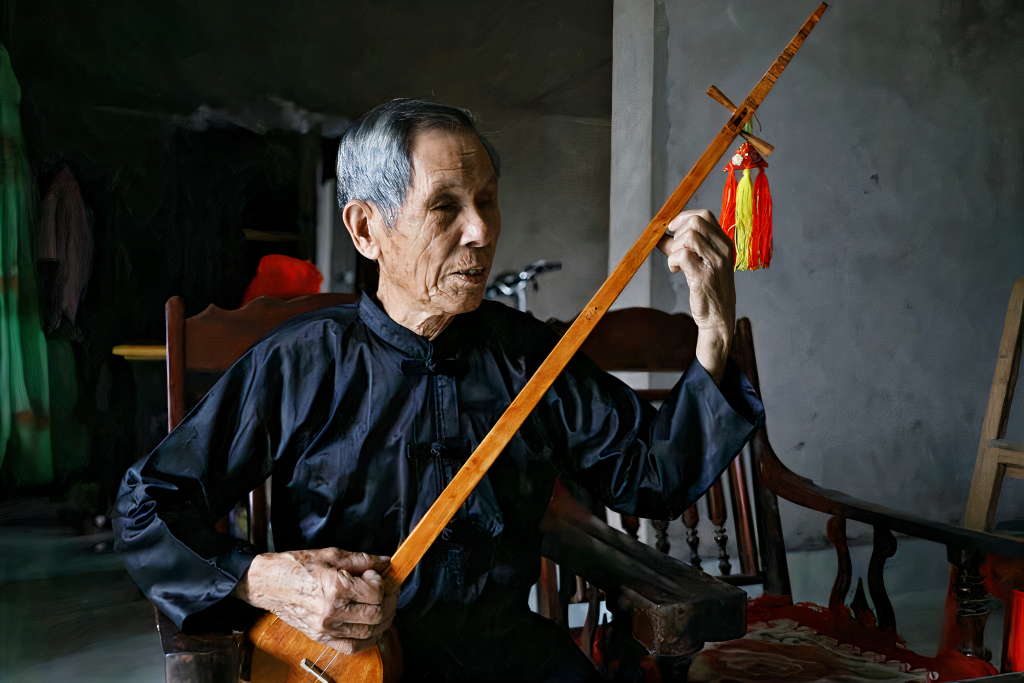 Nghệ nhân ưu tú Lương Thiêm Phú bên cây đàn tính do mình chế tác ra.