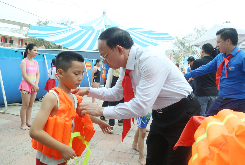 Đồng chí Nguyễn Xuân Ký, Bí thư Tỉnh ủy, Chủ tịch HĐND tỉnh, trao áo phao cho các em thiếu nhi học lớp bơi miễn phí tại Cung Văn hóa thanh thiếu nhi tỉnh. Ảnh: Thu Chung