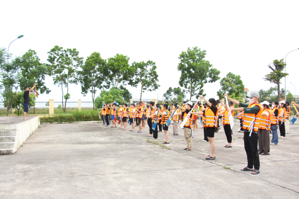 Các em học sinh cùng khởi động trước khi bơi thuyền chải.