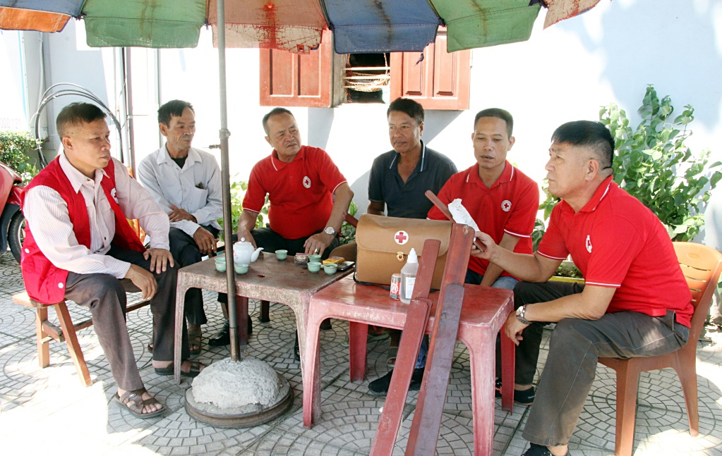 Ông Nguyễn Công Hoan (ngoài cùng, bên phải), Đội trưởng Đội tình nguyện viên sơ cấp cứu TNGT phía bắc cầu sông Chanh (TX Quảng Yên) chia sẻ kinh nghiệm, kỹ năng sơ cấp cứu TNGT với các tình nguyện viên trong đội.