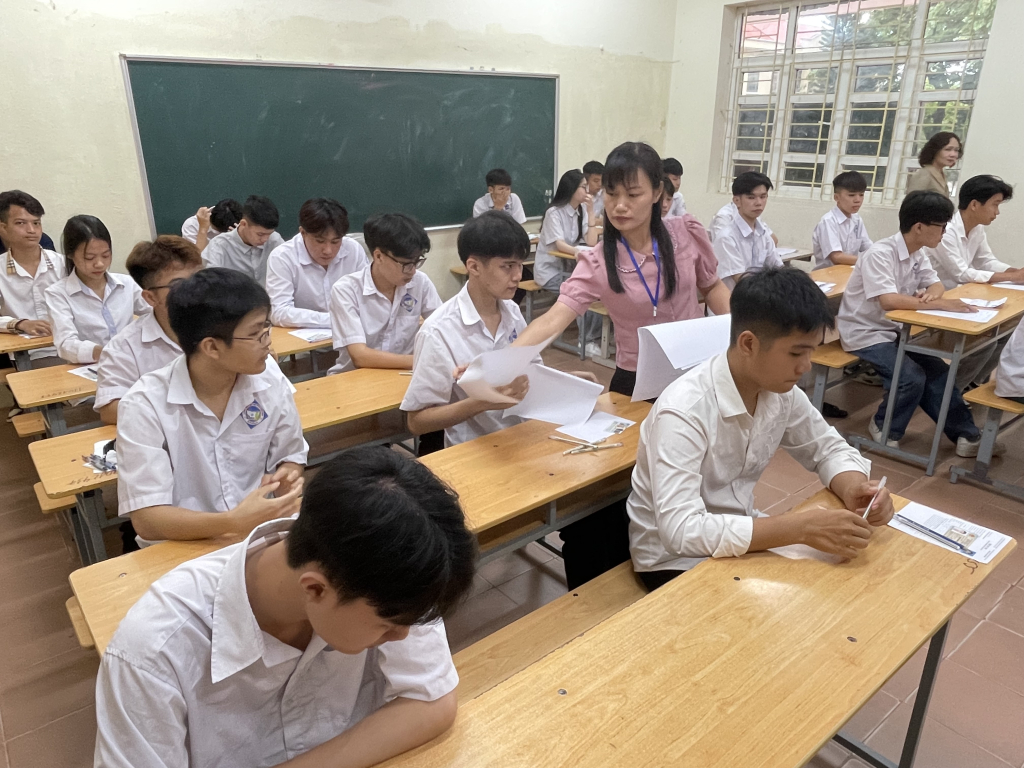 Giám thị phát giấy thi, giấy nháp cho các thí sinh.