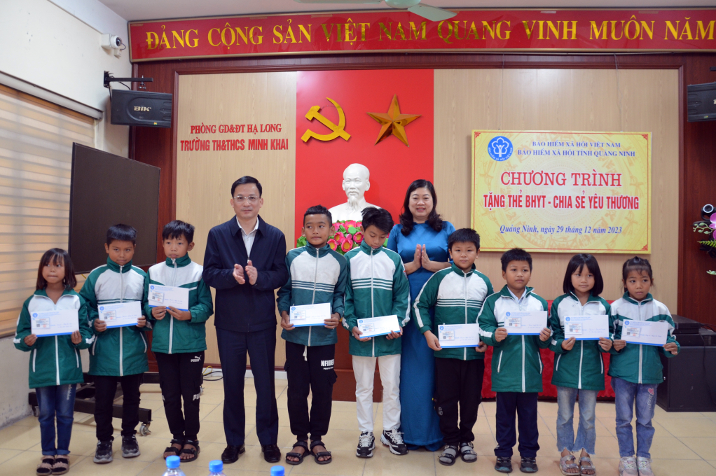 Lãnh đạo BHXH tỉnh cùng lãnh đạo Trường TH&THCS Minh Khai (phường Hà Phong, TP Hạ Long) trao tặng thẻ BHYT cho học sinh khó khăn, cuối năm 2023.