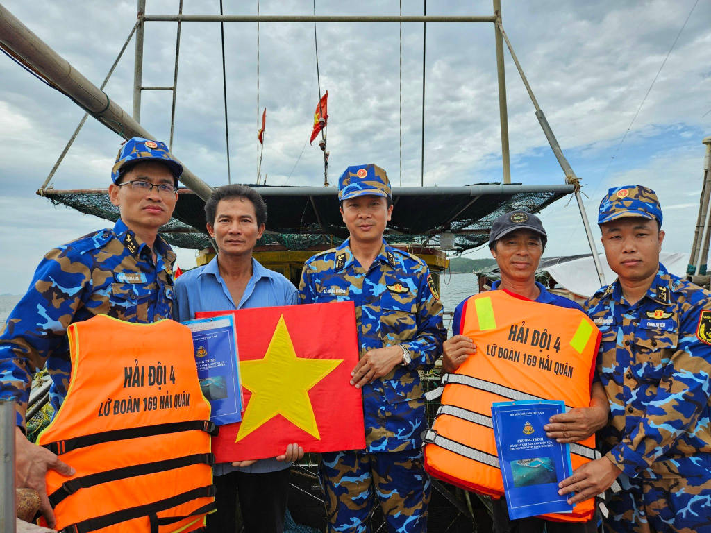 Thượng tá Lê Quang Trưởng, Phó Lữ đoàn trưởng cùng đoàn công tác trao tờ rơi và quà cho ngư dân.