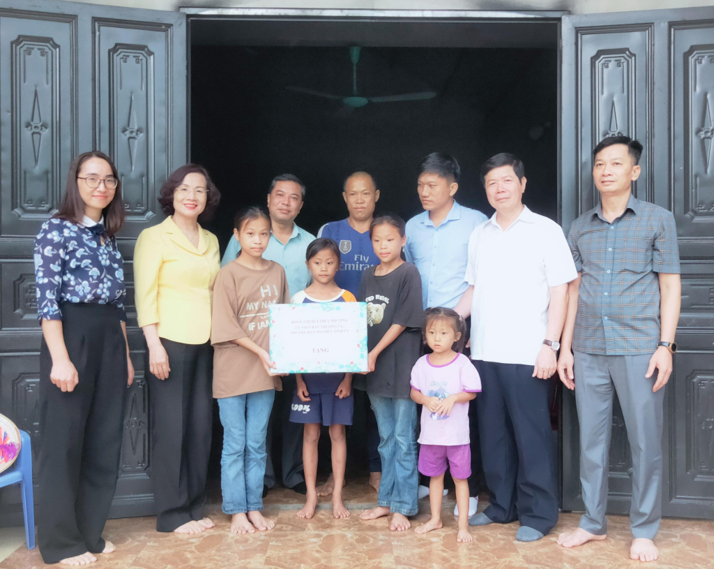 Đồng chí Trưởng Ban Tổ chức Tỉnh ủy và Đoàn công tác trao tặng quà đỡ đầu cho cháu Lý Minh Huyền.