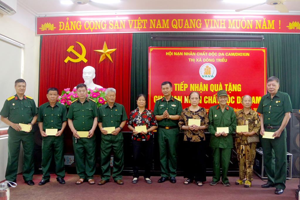 Thượng tá Phạm Quang Tiến, Phó Chủ nhiệm Chính trị Bộ CHQS tỉnh trao quà tặng các nạn nhân chất độc da cam/dioxin tại TX Đông Triều.