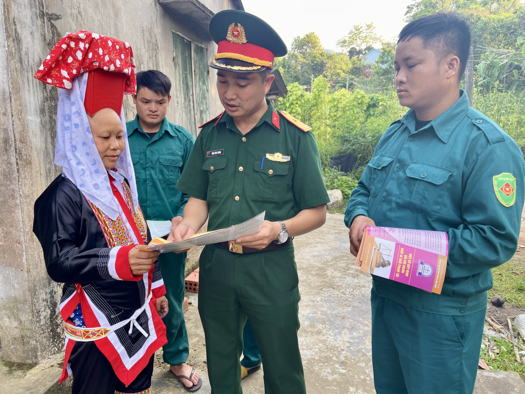 Cán bộ, chiến sĩ Ban CHQS huyện Bình Liêu phát tờ rơi tuyên truyền pháp luật cho người dân.