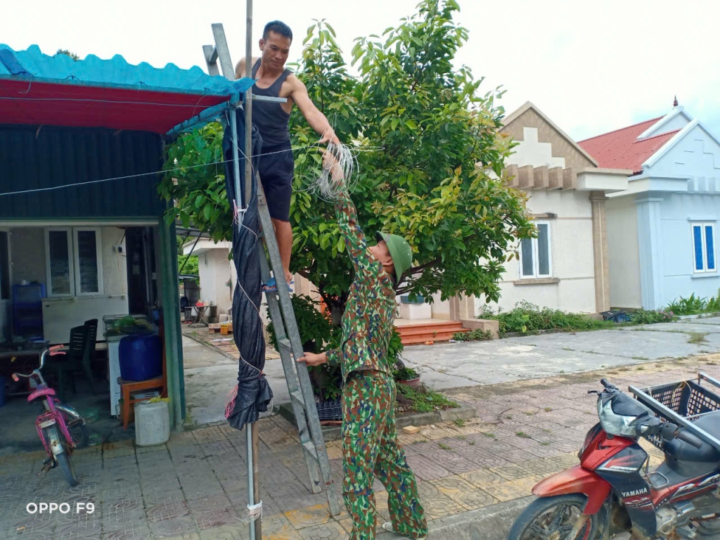 Cán bộ Đồn BP Đảo Trần giúp người dân chằng buộc nhà cửa chống bão.