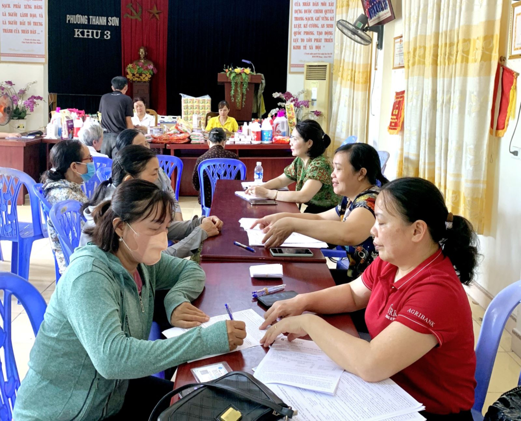 Cán bộ các ngân hàng tuyên truyền, hỗ trợ lập tài khoản ngân hàng cho người hưởng chế độ hưu trí, trợ cấp BHXH chuyển sang lĩnh qua thẻ ATM. Ảnh: Mai Hương (Uông Bí)