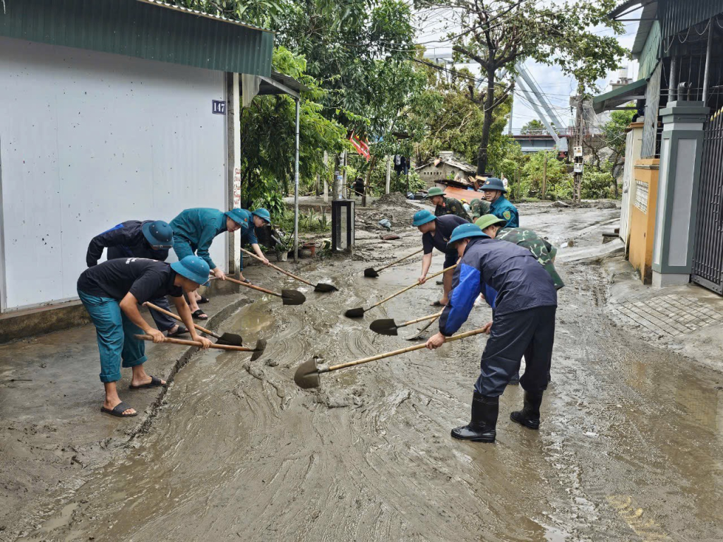 Lực lượng dân quân tự vệ tham gia dọn vệ sinh môi trường đường phố sau bão.