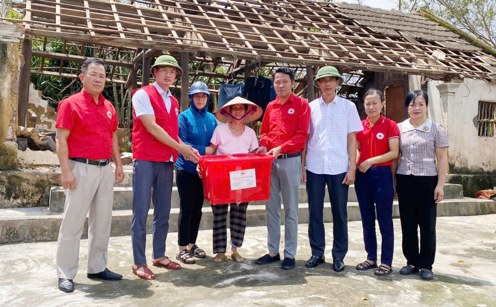 Lãnh đạo Hội Chữ thập đỏ tỉnh trao thùng hàng là nhu yếu phẩm thiết yếu hỗ trợ cho bà Bùi Thị Lan (thôn 13, xã Hiệp Hòa, TX Quảng Yên) bị đổ sập nhà do cơn bão số 3,