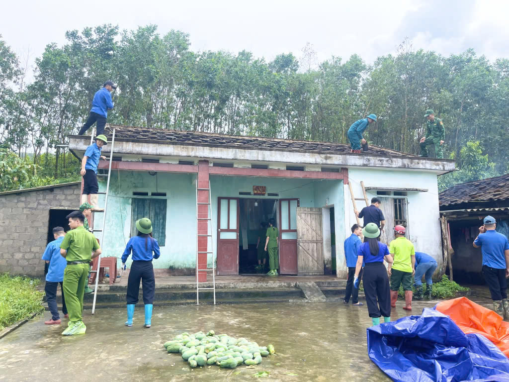 Đoàn viên thanh niên huyện Hải Hà, Đồn Biên phòng Quảng Đức, Chi cục Hải quan cửa khẩu Bắc Phong Sinh, Công an huyện và xã Quảng Đức hỗ trợ gia đình ông Tằng Cắm Dảu tháo dỡ hệ thống mái nhà bị tốc trong bão số 3. Ảnh: Trung tâm TT&VH Hải Hả.