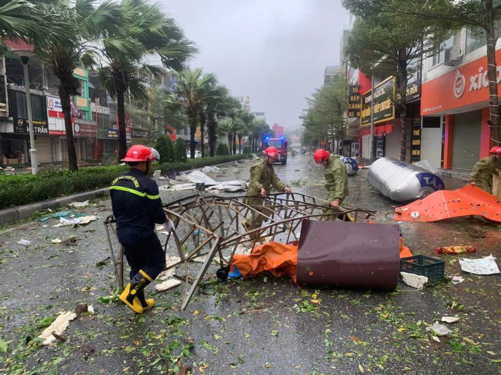Thiếu tá Nguyễn Trọng Bình và đồng đội dọn các vật cản nguy hiểm trên đường ngay khi cơn bão vừa qua.