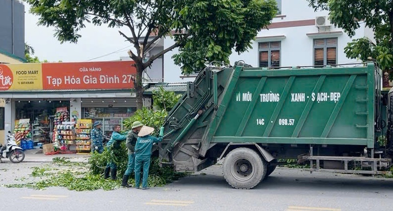 Công nhân Công ty CP Đầu tư và Phát triển MTĐT Quảng Ninh đưa rác thải lên xe chuyên dụng tại khu vực phường Hà Lầm để vận chuyển đi xử lý.