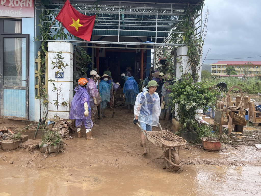 Người dân thôn Đá Trắng, xã Thống Nhất, thành phố Hạ Long hỗ trợ nhau dọn dẹp bùn đất tràn vào nhà sau ảnh hưởng của cơn bão Yagi. Ảnh: Minh Đức