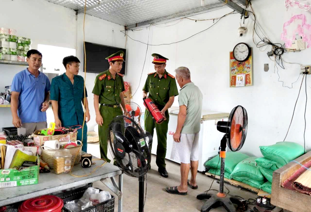 Công an xã Đồng Tiến (huyện Cô Tô) hướng dẫn công dân kiểm tra thiết bị chữa cháy sau bão số 3.