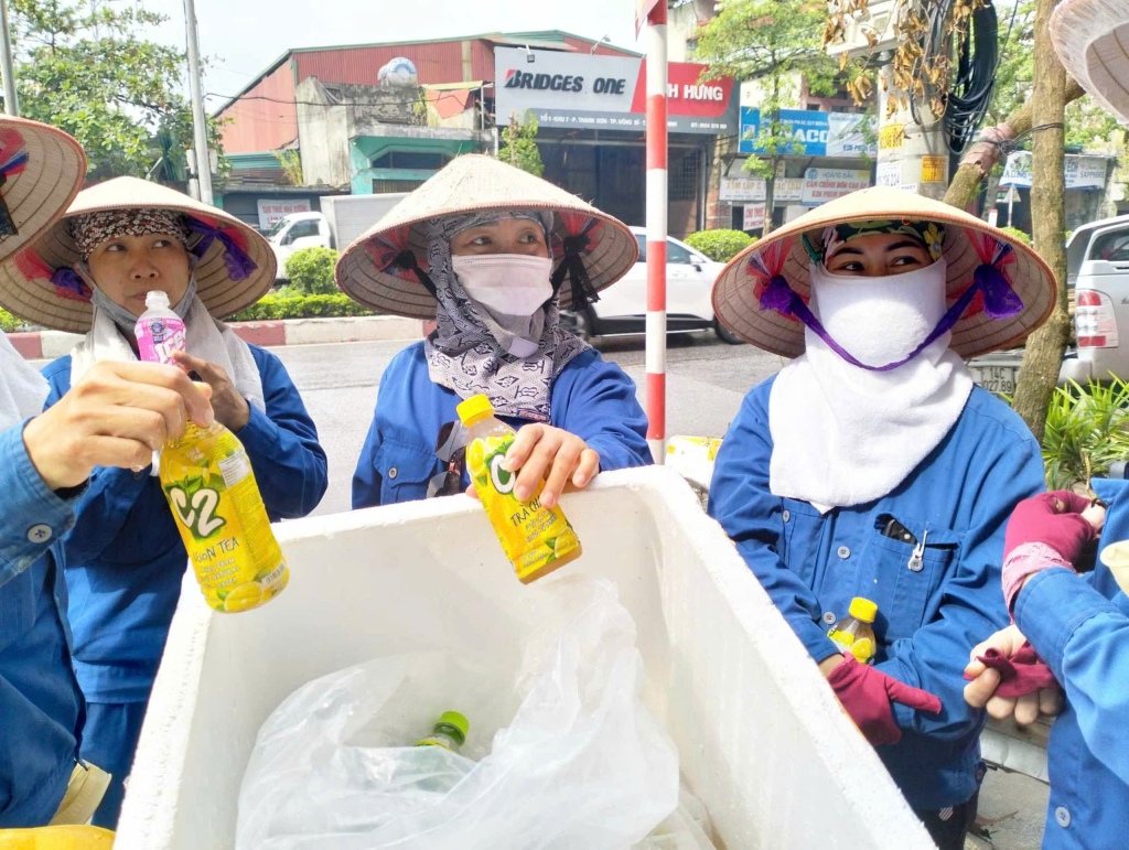 Công nhân vệ sinh môi trường Uông Bí phấn khởi nhận những chai nước mát lạnh từ nhóm của chị Đinh Thị Hoài Thanh. Ảnh Thanh Hùng (phương Phương Đông, TP Uông Bí)