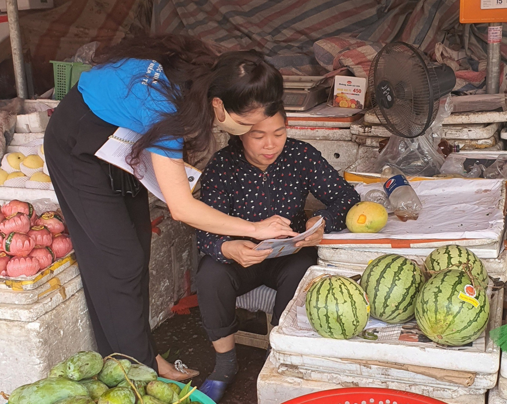 Nhân viên BHXH huyện Hải Hà tuyên truyền, hướng dẫn các tiểu thương chợ trung tâm Hải Hà 2 (huyện Hải Hà) tham gia BHXH tự nguyện, bảo hiểm y tế.