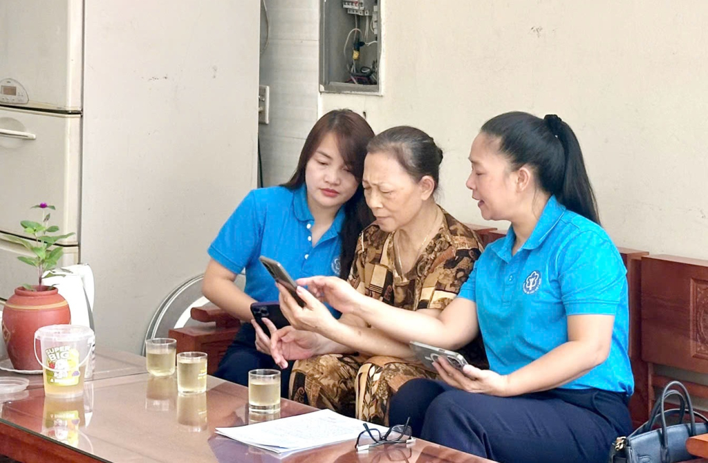 Cán bộ BHXH tỉnh hướng dẫn bà Nguyễn Hạnh Tâm (phường Cao Thắng, TP Hạ Long) thực hiện khảo sát của ngành BHXH.
