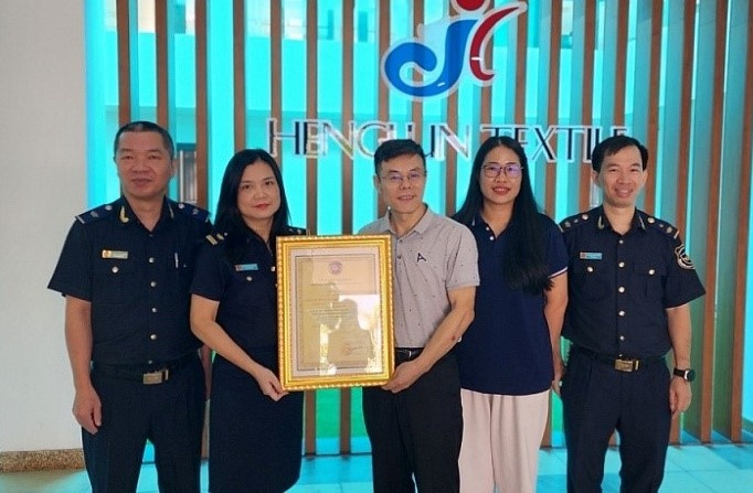 Lãnh đạo Chi cục Hải quan cửa khẩu Móng Cái trao giấy chứng nhận cho doanh nghiệp thành viên Chương trình thí điểm hỗ trợ, khuyến khích doanh nghiệp tự nguyện tuân thủ pháp luật hải quan. Ảnh đơn vị cung cấp