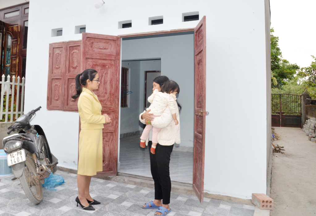 Bà Đặng Thị Mai Hạnh, hộ cận nghèo ở thôn Cây Sằm, xã Tiền An bên ngôi nhà mới được cấp ủy, chính quyền địa phương hỗ trợ xây dựng. 