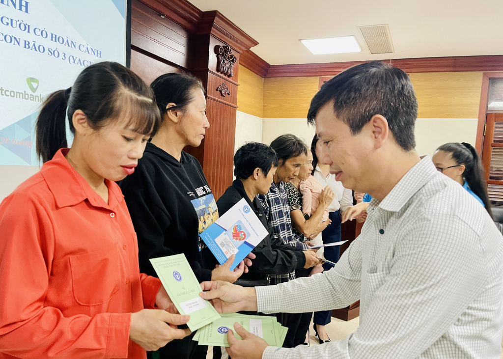 Ông Nguyễn Huy Thông, Phó Giám đốc BHXH tỉnh, trao tặng thẻ BHYT cho người dân có hoàn cảnh khó khăn trên địa bàn TP Hạ Long.  Ảnh: Hoàng Nga