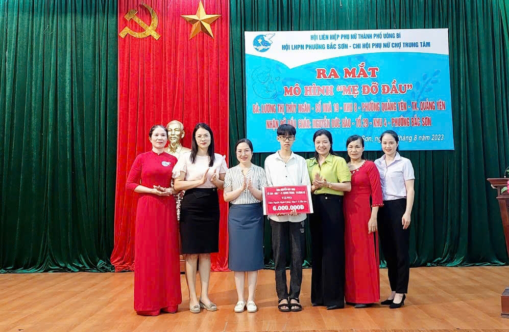 Cháu Nguyễn Mạnh Cường (đứng giữa) nhận kinh phí hỗ trợ từ ông Nguyễn Huy Ninh.