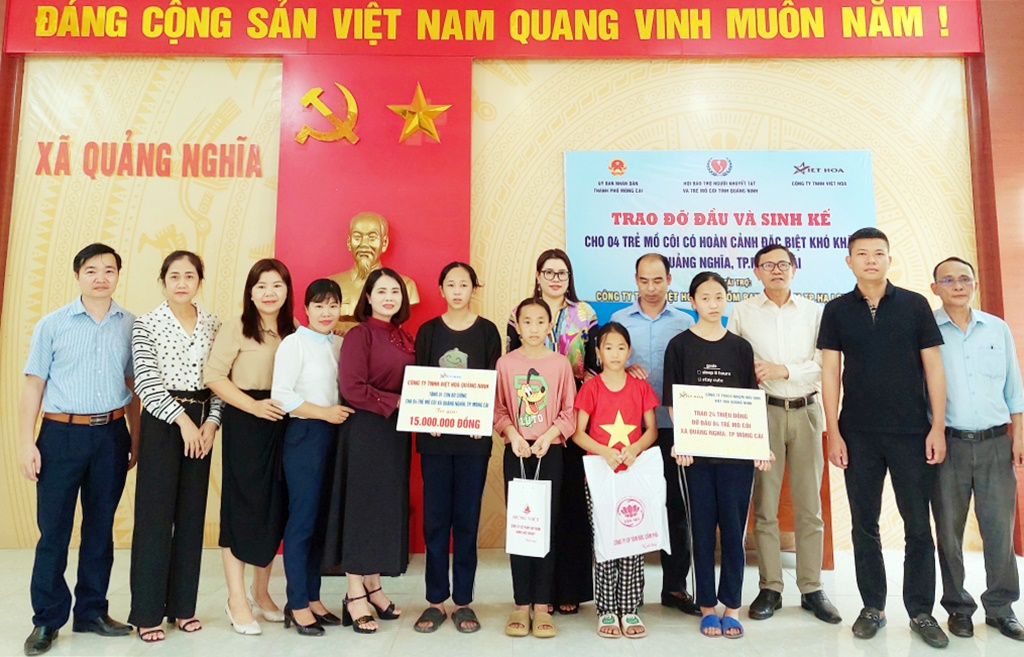 Giám đốc Công ty TNHH Việt Hoa Quảng Ninh Vũ Thị Thủy Vân (thứ 8, trái sang) cùng đại diện Hội Bảo trợ NKT-TMC tỉnh trao học bổng và tặng 1 con bò cho gia đình 4 học sinh mồ côi khó khăn tại thôn 4, xã Quảng Nghĩa (TP Móng Cái), tháng 4/2023.