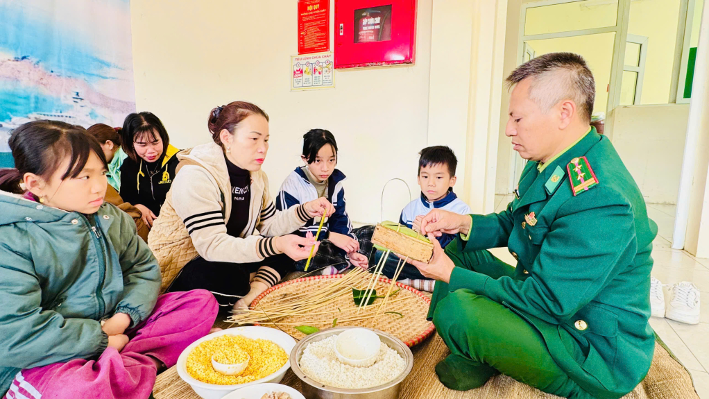 Các cháu học sinh trên đảo Trần thích thú khi được các chú bộ đội hướng dẫn cách thức gói bánh chưng truyền thống. 