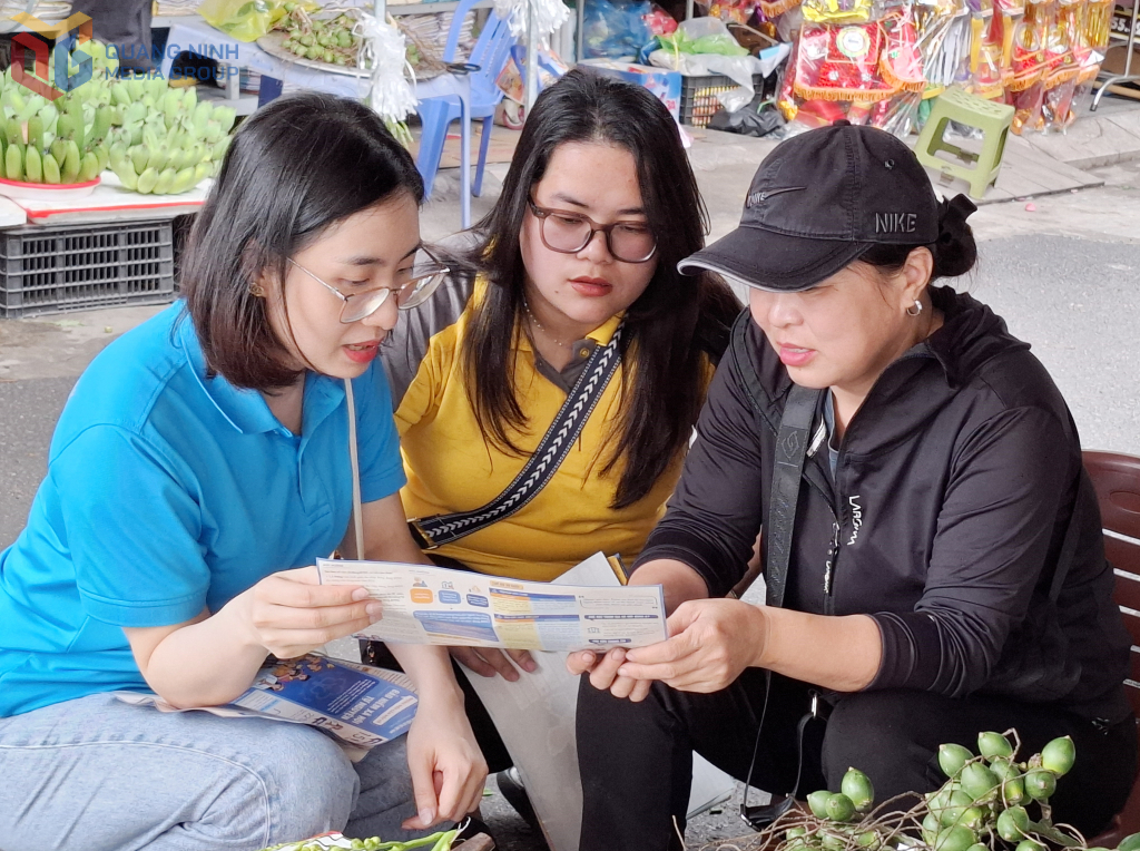 Cán bộ BHXH tỉnh và Bưu điện tỉnh giải thích về chính sách BHXH tự nguyện cho hộ tiểu thương tại Chợ Hạ Long 1 (TP Hạ Long) tháng 4/2025.