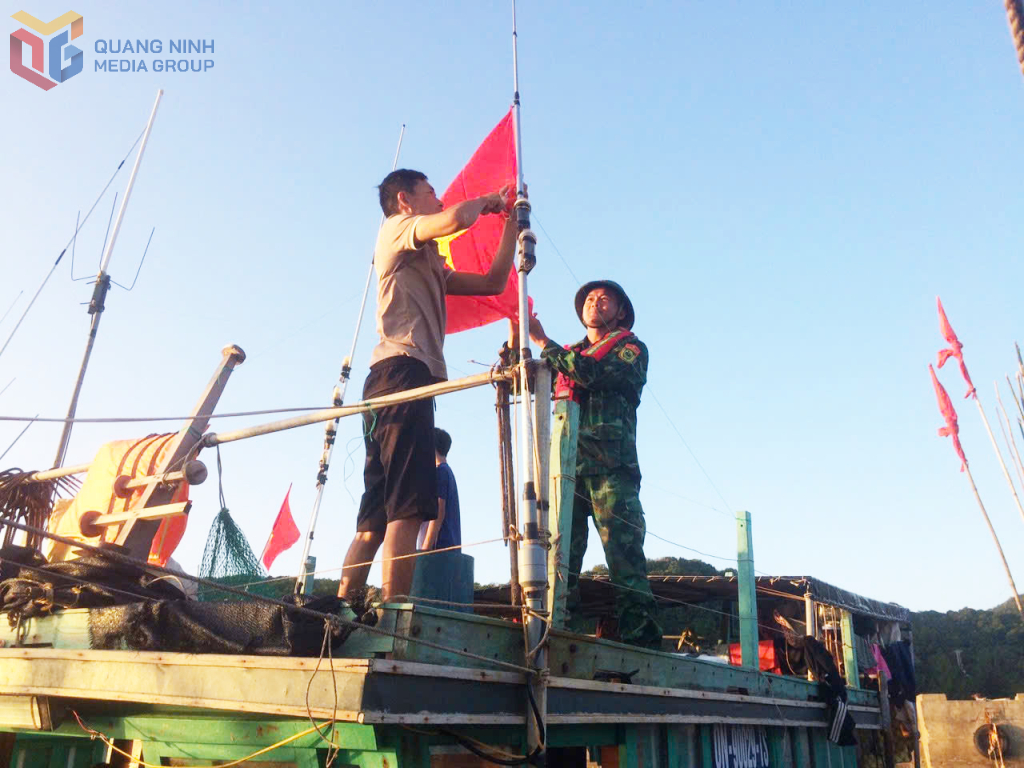 Thượng úy Nguyễn Bá Quân giúp ngư dân treo cờ Tổ quốc.